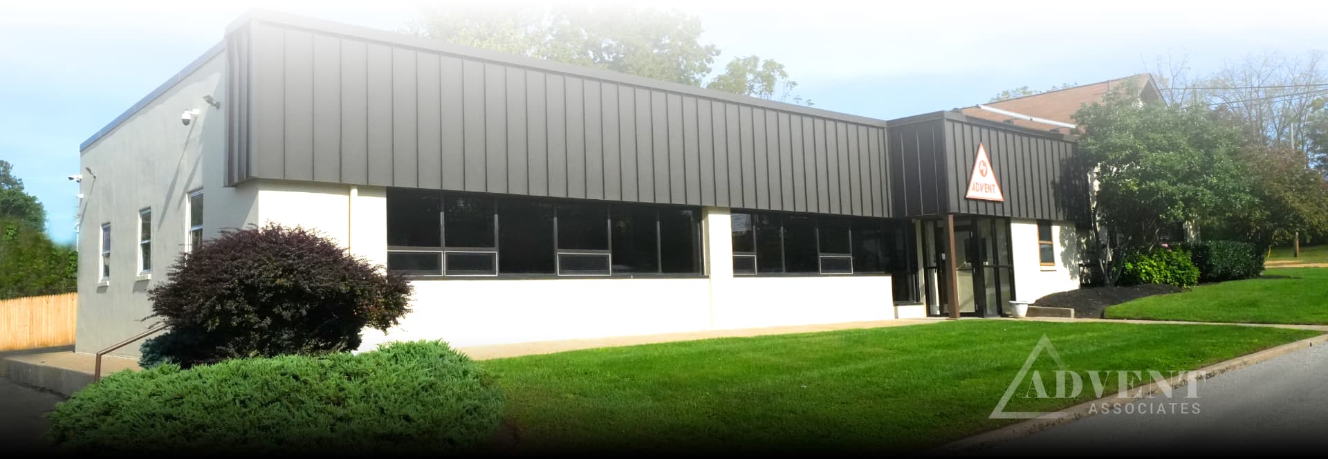 Corner angle of the Advent Associates building at 101 Roesch Avenue with lawn and entrance